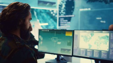 Ulusal uydu görüntülerini inceleyen bir bilgisayar uzmanı üsden genel merkeze gerçek zamanlı önemli bilgiler gönderiyor. Donanma Komutanı. Kamera B.