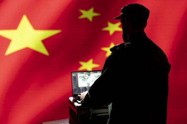 Çinli ordu uzmanı, veri analizi için dizüstü bilgisayardaki yazılımları kullanarak taktiksel keşif yapıyor. Komuta odasındaki CCP askeri ajanı ekrandaki hava haritasına bakıyor