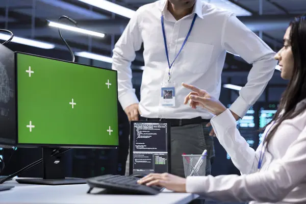 stock image Software developers doing checkup on green screen computer in server room used for artificial intelligence workloads. IT staff members inspecting neural network data center facility with mockup PC