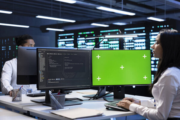 Specialists using green screen PC to check server clusters configuration settings. Engineers checking event logs in monitoring software to find faulty data center hardware root cause