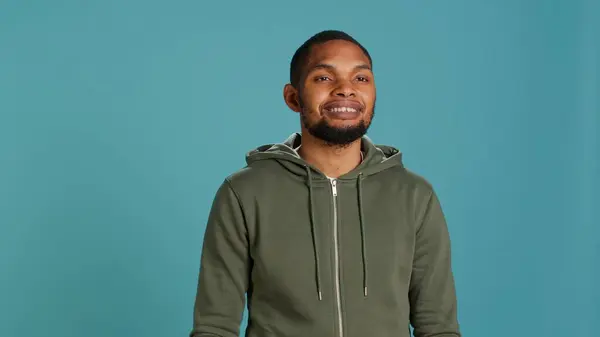 stock image Portrait of cheerful african american man smiling, waving hand, isolated over studio background. Happy expressive person saluting person off camera, being friendly, camera A