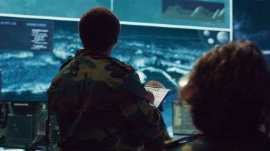 Tuğgeneral kadın, ulusal güvenliği sağlamak için büyük ekranda istihbarat raporları topluyor. Özel bir görev için planlama ve koordinasyon, askeri keşif sistemi. Kamera A.