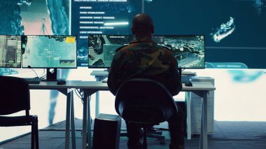 Ordu subayı, dünya haritası uydu görüşü üzerinden yeni operasyon üsleri kuruyor. Güç üssü komuta merkezine bağlanılmasını sağlıyor. Komutan CCTV radar görüntülerini yönetiyor. Kamera A.