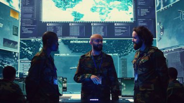 Donanma operasyon uzmanları, bir hologram vasıtasıyla gözetleme radarlarını izliyorlar. Bir askeri kontrol merkezinde üç boyutlu çizimler üzerinde çalışıyorlar. Generallerden oluşan bir ekip istihbarat topluyor. Kamera B.