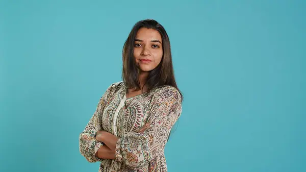 stock image Portrait of optimistic indian woman wearing colorful clothes with positive facial expression smiling, looking pleased. Calm person in traditional clothing feeling satisfied, studio backdrop, camera A