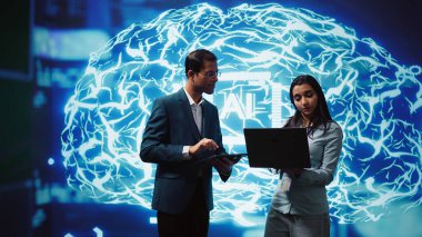 İnsan beyninden esinlenilmiş yapay zeka ağlarını kullanan iş arkadaşları karmaşık sorunları çözmek için beyin fırtınası yapıyorlar. Bilgi işlem personeli veriye ve tam görevlere bakmak için derin öğrenim kullanıyor, kamera B