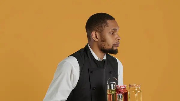 stock image Waiter bringing drinks in glasses on a tray for clients at a table, serving lemonade to customers before their dinner. Professional staff serving people at a five star restaurant. Camera A.