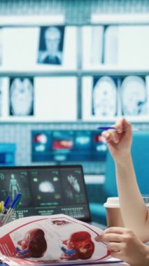 Dikey video kadın doktor ve hasta röntgen sonuçlarının taranması için tıbbi konsültasyona giriyorlar. Modern sağlık uygulamaları ve tıbbi araştırmaları vurgulayan hekim uzmanı
