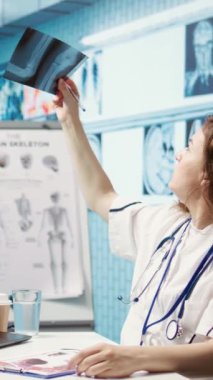 Dikey Video Medikal personeli teşhis raporlarını inceliyor ve röntgen görüntüleme ve tarama yorumlarına odaklanıyor. Modern sağlık muayenesi ve klinikte hasta teşhisi