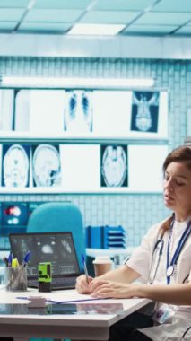 Dikey Video Uzmanı tavsiye edilen antibiyotiklerle reçeteli ilaç yazıyor ve hastalara talimatlar veriyor. Sağlık sigortası için reçeteli tedavi hapları