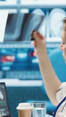 Dikey Video Medikal personeli teşhis raporlarını inceliyor ve röntgen görüntüleme ve tarama yorumlarına odaklanıyor. Modern sağlık muayenesi ve klinikte hasta teşhisi