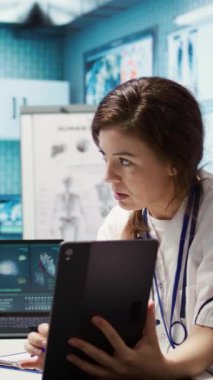 Tablet üzerinde tarama yorumu yoluyla test bulgularını sunan Dikey Video Genel uygulayıcısı, tanısal ve olası tedaviyi tartışıyor. Tıbbi uzman hastaya tavsiye veriyor