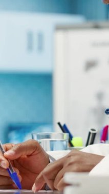 Dikey Video Erkek Hekimi, muayene sırasında röntgen taraması yaparak kabinedeki iyileşme tedavisini tartışıyor. Radyografi testinin sonuçlarını inceleyen doktor...