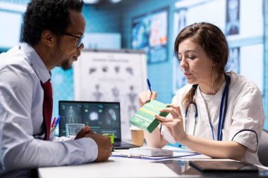 Doktor, ilaç ve ağrı kesicileri, ilaç kutularını reçeteli tedaviye vererek, ecza dolabındaki hastasına tavsiye ediyor. Sağlık uzmanı takviye ve antibiyotik sağlıyor.