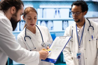 Çeşitli doktorlar hastane kayıtlarını ve röntgen sonuçlarını inceliyor. Doğru tanıyı koymak için tomografi ve radyografiye bakıyorlar. Uzmanlar hastalıkların önlenmesini sağlamak için takım çalışması yapıyorlar.