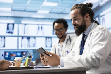 Sağlık uzmanları, test sonuçları ve radyografi taramalarını gözden geçirmek üzere bir klinikte toplandılar. Uzman doktorlar doğru teşhis ve sağlık hizmetleri için toplu çalışma sağlarlar.
