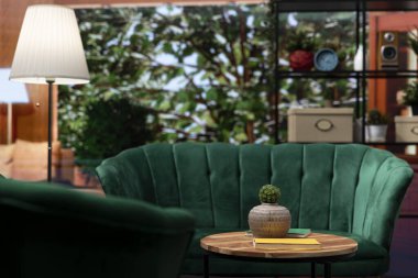 Zarif yeşil sandalyelerle, ahşap masalarla, aydınlık boşluklarla dolu boş bir ev. Modern mobilyalar ve ormana bakan panoramik pencereler. Ormanda İskandinav tarzı kulübe.