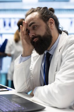 Genel pratisyen doktor tıbbi kayıtları ve test sonuçlarını inceledikten sonra yorgun ve stresli hissediyor, tedavi merkezinde iyileşme garantisi veriyor. Doktor, hastalığın tedavisini bulmak için baskı altında çalışıyor..