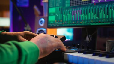 Ses mühendisi, ses efektleri ve amfi öncesi düğmelerle çalışan ev stüdyosundaki karıştırma konsolu üzerine yeni müzik yapıyor. Yetenekli yapımcı şarkılar yaratıyor ve ses seviyelerini ayarlıyor. Kapatın. Kamera B.