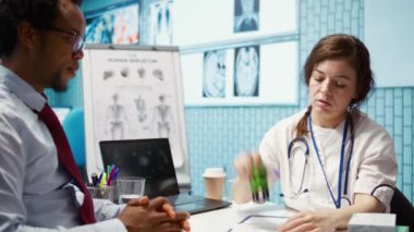 Doktor, sağlık sigortasına vitamin ve ağrı kesici verilmesini tavsiye ediyor. Talimatları ve ilaçların dozunu içeren mühürlü bir reçete yazıyor. Modern sağlık hizmetleri. Kamera B.