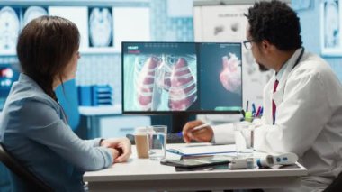 Tıbbi uzman, iç organların taramalarını kabinedeki kadına gösteriyor. Teşhis ve sağlık tedavisi sunuyor. Sağlık sektöründe çalışan modern bir doktor, sağlık sigortası. Kamera A.