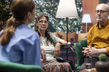 Yaşlı kadın tekerlekli sandalye kullanıcısı ev ziyareti sırasında hemşireden tıbbi tavsiye ve hap ister, teşhisi açıklayan yardımcı ve sağlık ve iyileşme için gerekli ilaçları yazar.