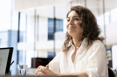 Kariyerinde ilerlemek isteyen gülümseyen bir iş görüşmesi adayı insan kaynakları uzmanıyla konuşuyor. Neşeli bir kadın, üst düzey bir iş için işe alınmak istiyor.