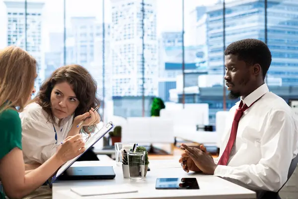 stock image Team of employers conducting interview with man to determine their suitability for company position. HR department colleagues reviewing resume to determine if necessary qualifications are met