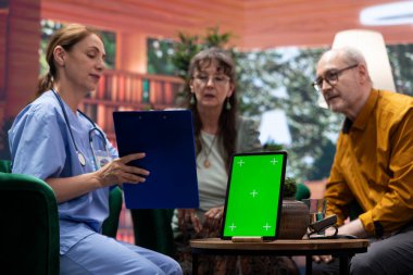 Hasta bakımı için yaşlı çiftleri evlerinde ziyaret eden tıbbi asistan, izole gösteriler yapıyor ve iyileşme için vitamin ve tedavi için konsültasyon yapıyor. Hemşire kıdemli hastalarla konuşuyor..