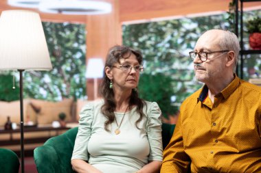 Oksimetresi ve oksijen tüpü olan yaşlı bir adam evde sağlık hemşiresiyle sağlık kontrolünde ağrı ve hastalıkları tartışıyor. Serum torbasıyla vitamin vermesine yardımcı oluyorum..