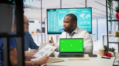 Yaşlılar kroma anahtar ekranının yanında bir finans uzmanıyla bir araya gelerek, çeşitli emeklilik seçeneklerini araştırıyor ve gelecek için tasarruflarını güvence altına alıyorlar. Yatırım stratejisi tavsiyesi. Kamera B.