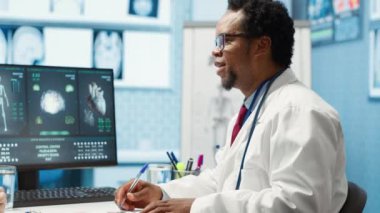 Afro-Amerikalı hekim kadın hastaya, hastalık tedavisi ve test sonuçları analizi konusunda profesyonel tavsiyelerde bulunuyor. Doktor uzman, sağlık sektöründe çalışıyor. Kamera A.