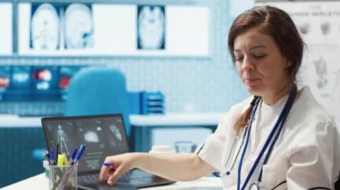 Tıbbi uzman test sonuçlarını sağlık ortamındaki bir hastayla tartışıyor, doğru tıbbi analiz ve danışma için teşhis araçları ve bilgisayar teknolojisinden faydalanıyor. Kamera A.