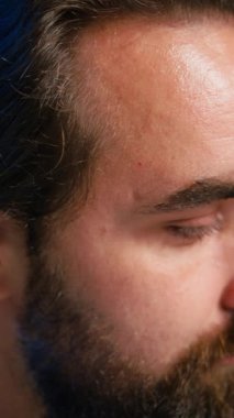 İçerik yaratıcısının dikey video portresi stüdyoda ASMR videosu çekmek için yüksek kaliteli mikrofon kullanarak izleyicilerle tartışıyor. Gülümseyen adam podcast kaydetmek için profesyonel mikrofon kullanıyor, kamera B kapanıyor