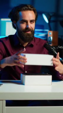 Dikey video teknolojisi gurusu profesyonel kamerayı kullanarak yeni cep telefonunun teknik incelemesini kaydediyor ve boks videosu açıyor. İçerik oluşturucu abonelere telefon kulübesini gösteriyor, yüksek teknoloji teçhizatıyla kayıt yapıyor