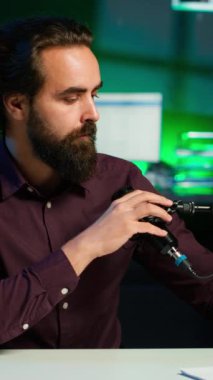 rgb lights stüdyosunda internet şovu sunan iyimser içerik yaratıcısının dikey video portresi profesyonel mikrofon kullanarak vlog çekiyor. Neşeli vlogger canlı yayın yapıyor, kamera A