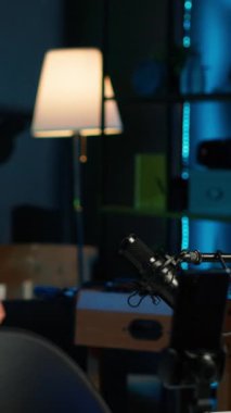 Vlog 'a başlamadan önce stüdyodaki profesyonel mikrofonu ayarlayan dikey video içerikli yaratıcı selfie kamerayla kayıt yapıyor. Neon ışıklı ev stüdyosu hazırlayan, akıllı telefonlu çekim yapan adam.