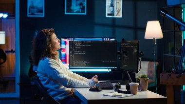 Bilgi teknolojileri uzmanı, geliştirilmiş gerçekliği kullanarak programları test ediyor ve harekete geçiriyor. Bilgisayar monitöründeki kodları kontrol eden programcı ve AR görselleştirmesi, apartmandaki masa sandalyesinde oturmak, kamera A