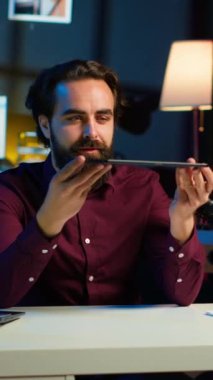 Dikey video teknisyeni, düşük bütçeli tableti ilgili izleyicilere stüdyoda sunuyor. İnternet önünde dijital aygıtı inceleyen viral içerik oluşturucu