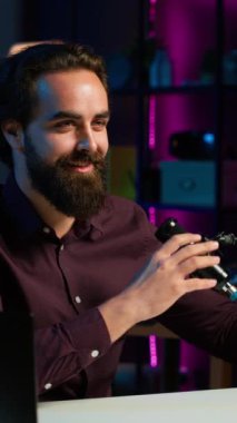 Dikey video içerikli yapımcı, kendi hakkında konuşurken ev stüdyosundaki üretim ekipmanlarıyla birlikte geceleri RGB ışıklarıyla aydınlanan bir video kaydediyor. Profesyonel olarak konuşan bir şovmen.