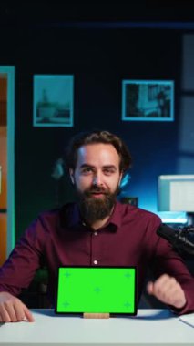 Stüdyoda gülümseyen adam teknoloji meraklıları için krom anahtar değerlendirmesi yapıyor. Neşeli çevrimiçi yıldız teknoloji internet şovuna ev sahipliği yapıyor, yeşil ekran dijital taşınabilir cihaz, kamera B