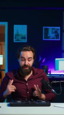 Dikey video sanatçısı DJ 'i filme alıyor, ses denetleyicisinden izleyicilere örnekler gösteriyor. Modern müzik ekipmanlarını ev stüdyosundaki abonelere gösteren viral internet yıldızı, kamera