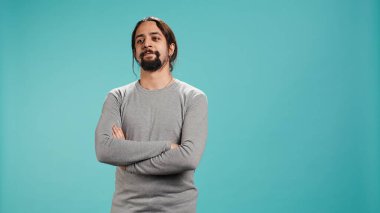 Gülümseyen, mutlu görünen, mavi stüdyo arka planında izole edilmiş neşeli bir Arap portresi. Mutlu dışavurumcu kişi şık giyinmiş sırıtıyor, tatmin olmuş hissediyor, kamera B