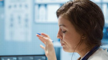 Kadın doktor ve hasta röntgen sonuçlarının taranması için tıbbi konsültasyona giriyorlar. Modern sağlık uygulamalarını ve tıbbi araştırmaları vurgulayan bir doktor. Kamera A.