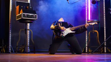 Confident female rocker performing live with a bass guitar on stage, showing her bold style and powerful rock star energy. Iconic loud heavy metal live performance, punk rock. Camera A. clipart