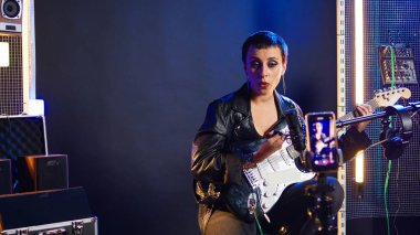 Stüdyoda ses eğitimi için çevrimiçi bir ders kaydeden şarkı söyleme koçu, canlı yayın dersi üzerine ses alıştırmaları. Heavy metal çalan bir müzik hocası temel şeyleri öğretiyor. Kamera A.