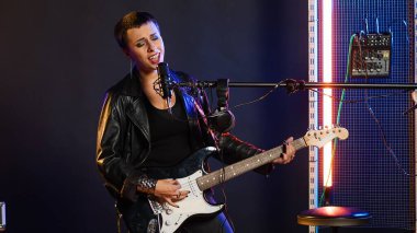 Canlı bir rock performansı sırasında güçlü bir şiddetle elektro gitarını çalan kadın şarkıcı. Sahnedeki konserin bir parçası olarak heavy metal şarkıları söyleyen bir müzisyen. Kamera B.