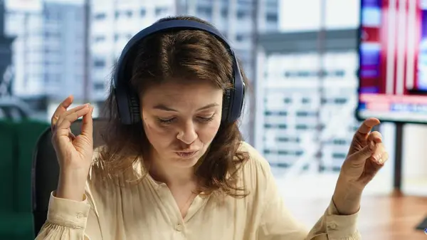 Stock image Business entrepreneur enjoys working with music on her headset, solving daily tasks at her corporate office. Determined powerful female CEO having fun with favorite songs, productivity. Camera A.