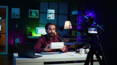 Profesyonel kamera kullanarak teknoloji vlog 'u için paketlenmiş ürün açma konusunda uzman. Influencer taraftarları sponsor ortak ürünleri satın almaya teşvik ediyor, yüksek kaliteli ekipmanlı video kaydı, kamera B