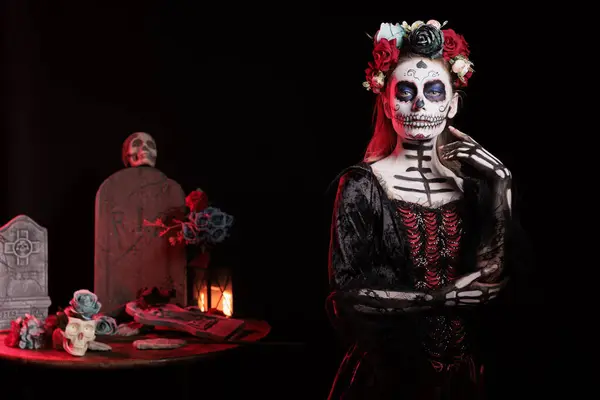 stock image Woman dressed in Day of the Dead horror costume with flower headband celebrating Dia de los Muertos. Girl wearing scary skeleton corpse makeup promoting Mexican culture during Halloween